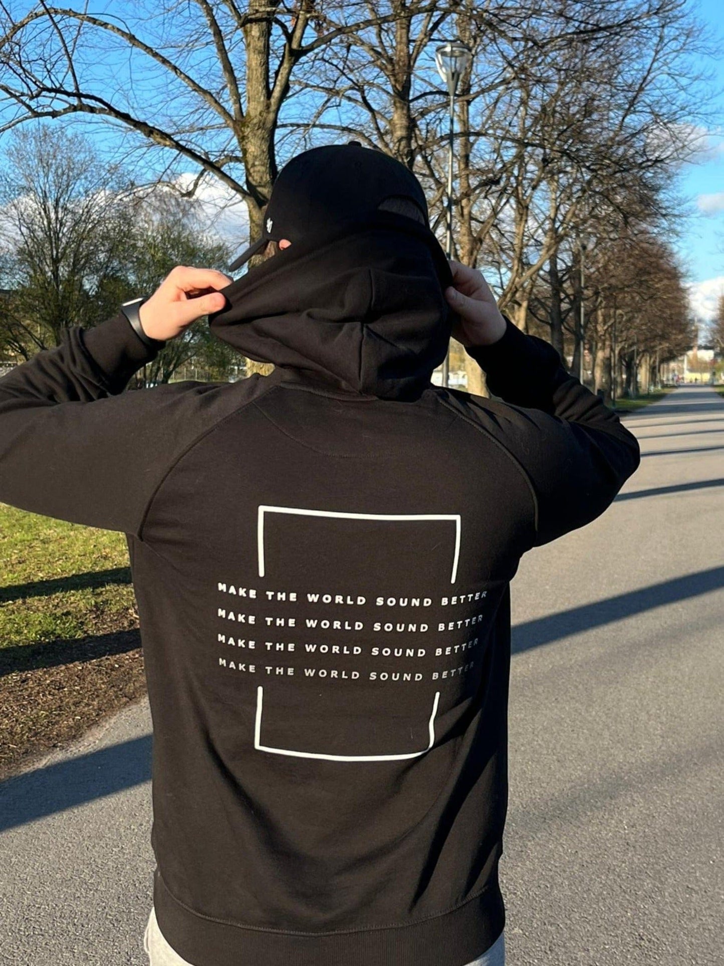 make the world sound better white print hoodie in use, from the back