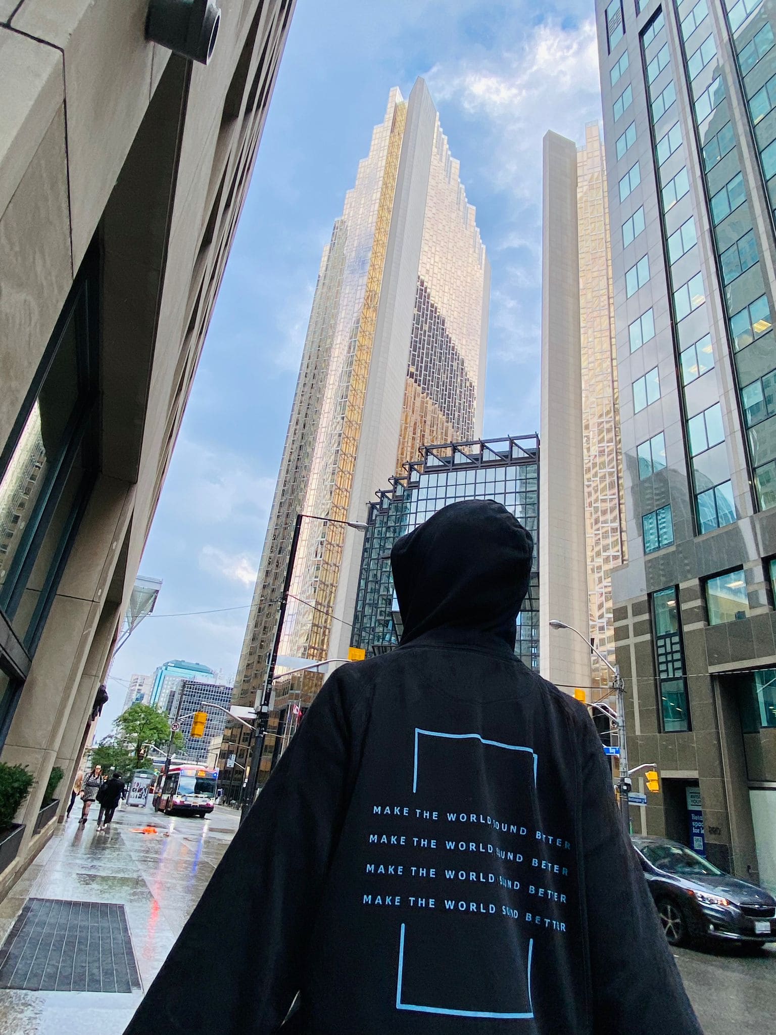 person standing with black hoodie in skyscraper view